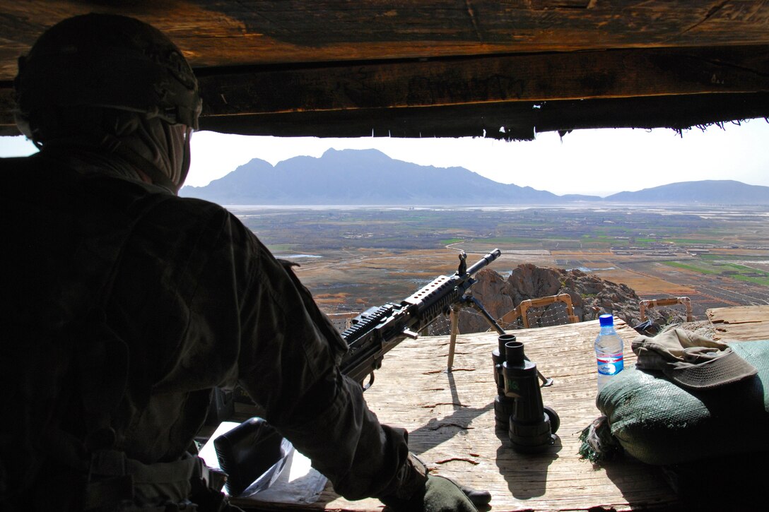 A U.S. soldier stands watch overlooking the valley south of Forward Operating Base Masum Ghar, a coalition outpost in the Panjwayi district of Kandahar province, Afghanistan, March 3, 2014. The soldier is assigned to 2nd Cavalry Regiment.