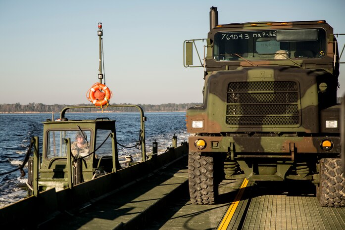 A Marine with Bridge Company, 8th Engineer Support Battalion, 2nd Marine Logistics Group steers an Improved Ribbon Bridge with an MK III Bridge Erection Boat near Camp Lejeune, N.C., March 10, 2014. Boats and IRBs were used to move heavy equipment and Marines across the New River to rifle ranges as part of an annual training exercise. (U.S. Marine Corps photo by Lance Cpl. Shawn Valosin)