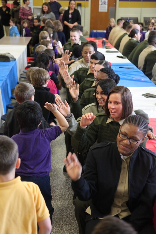 Students at Chicod School in Greenville, N.C., give high-fives to Marines and sailors during a National School Breakfast Week event, March 7, 2014. The service members volunteered through the Cherry Point Single Marine Program to help inform and encourage students to eat healthy. 