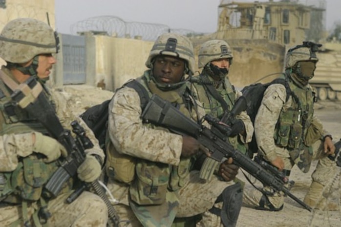 U.S. Marines prepare to step off on a patrol through the city of Fallujah, Iraq, to clear the city of insurgent activity and weapons caches as part of Operation al Fajr (New Dawn) on Nov. 26, 2004. The Marines are (from left to right) Platoon Sergeant Staff Sgt. Eric Brown, Machine Gun Section Leader Sgt. Aubrey McDade, Radio Operator Cpl. Steven Archibald, and Combat Engineer Lance Cpl. Robert Coburn. All were assigned to 1st Battalion, 8th Marine Regiment, 1st Marine Division conducting security and stabilization operations in the Al Anbar Province of Iraq.