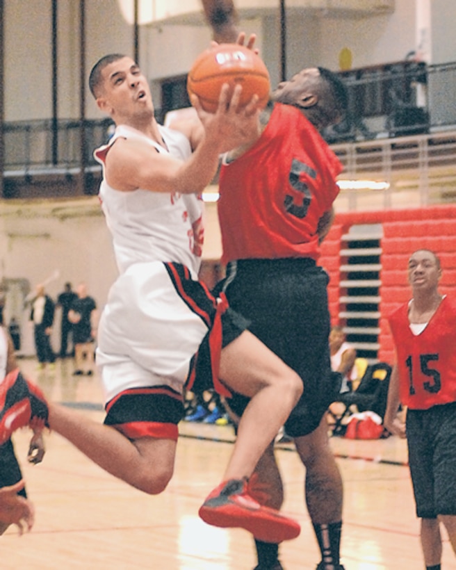 Marcus Jensen, Marine Det., pivots in midair to get around Jared Scott, 5th Engr. Bn., on his way to the basket in the first half.