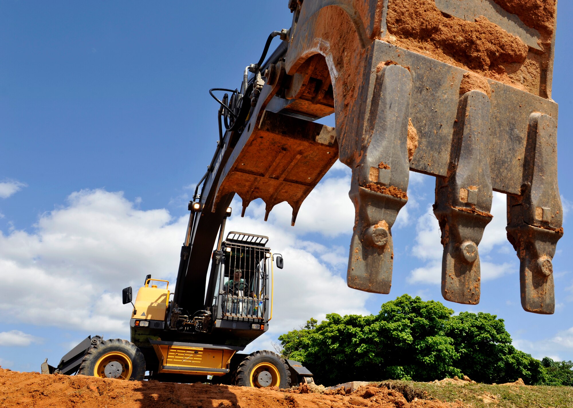 Airman 1st Class Sean Hayden operates an excavator to smooth out soil March 11, 2014, on Kadena Air Base, Japan. Members of the 18th Civil Engineer Squadron replaced a broken water pipe after it cracked and caused a rain runoff ditch to flood. Hayden is a pavement equipment technician with the 18th CES. (U.S. Air Force photo/Naoto Anazawa)