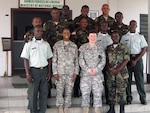 Army Capt. Margaret Mieras and Master Sgt. Angela Adams, both of Michigan, gather with members of the Ministry of Defense and Armed Force of Liberia administrative staff in Monrovia, Liberia on Feb. 20, 2014.