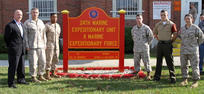 Marines and Sailors with the 24th Marine Expeditionary Unit pose with Tim Sutton, a survivor of the Beirut Bombing, outside of the 24th MEU command building aboard Camp Lejeune, N.C., Oct. 23, 2013. The group photographed ran in honor of the Marines from the state of Massachusetts, who lost their life during the bombing 30 years ago.