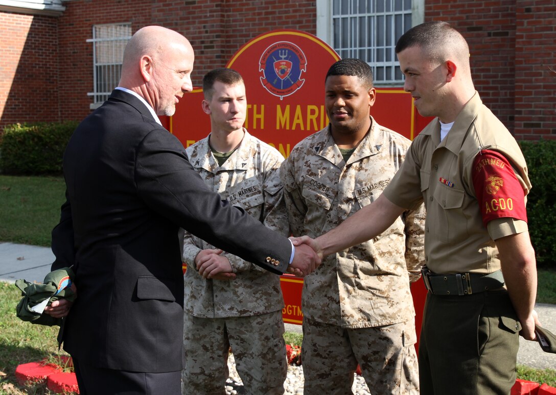 Lance Cpl. Walter Shearer, an administrative specialist with the 24th Marine Expeditionary Unit, shakes the hand of Tim Sutton, a survivor of the Beirut bombing, outside of the unit’s headquarters building Oct. 23, 2013. Shearer, a New Bern, N.C. native, ran in honor of Cpl. Sean Gallagher of North Andover, Mass., who was one of the 241 Marines, Sailors and soldiers who lost their life during the bombing 30 years ago.