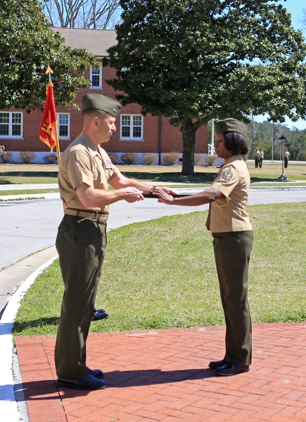 Col. Scott F. Benedict, the commanding officer of the 24th Marine Expeditionary Unit, passes the non-commissioned officer's sword to Sgt. Maj. Lanette Wright during a relief and appointment ceremony aboard Camp Lejeune, N.C., March 14, 2014. Wright, a Boca Raton, Fla., native, is the first female MEU sergeant major in Marine Corps history.