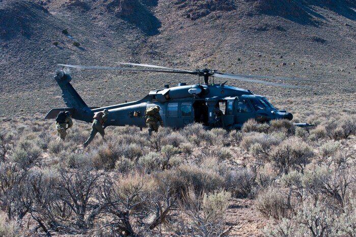 A U.S. Air Force Survival Evasion Resistance and Escape specialist (right), Senior Captain Beguin “Jeff” Jean-Francois, a pilot with the Belgian air force (middle), and a Belgian military member (left), run to an HH-60G Pave Hawk assigned to the 66th Rescue Squadron, Nellis Air Force Base, Nev. while participating in a combat search and rescue exercise during Red Flag 14-2 March 11, 2014, on the Nevada Test and Training Range. The three service members were running to the HH-60G to evacuate the area during a CSAR training mission. Training for CSAR missions is intended to increase the success rate of future real-world operations. (U.S. Air Force photo by Airman 1st Class Thomas Spangler) 
