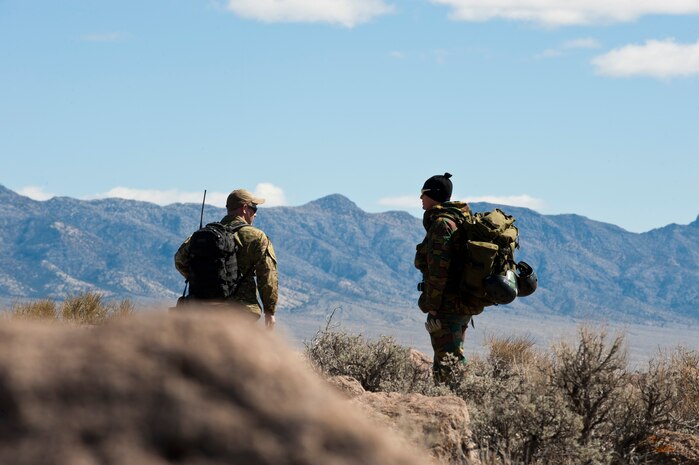 A U.S. Air Force Survival Evasion Resistance and Escape specialist (left), and a Belgian military member scan the area while participating in a combat search and rescue exercise during Red Flag 14-2 March 11, 2014, on the Nevada Test and Training Range. Red Flag exercises have evolved to include all aspects of air warfare including CSAR operations. (U.S. Air Force photo by Airman 1st Class Thomas Spangler)