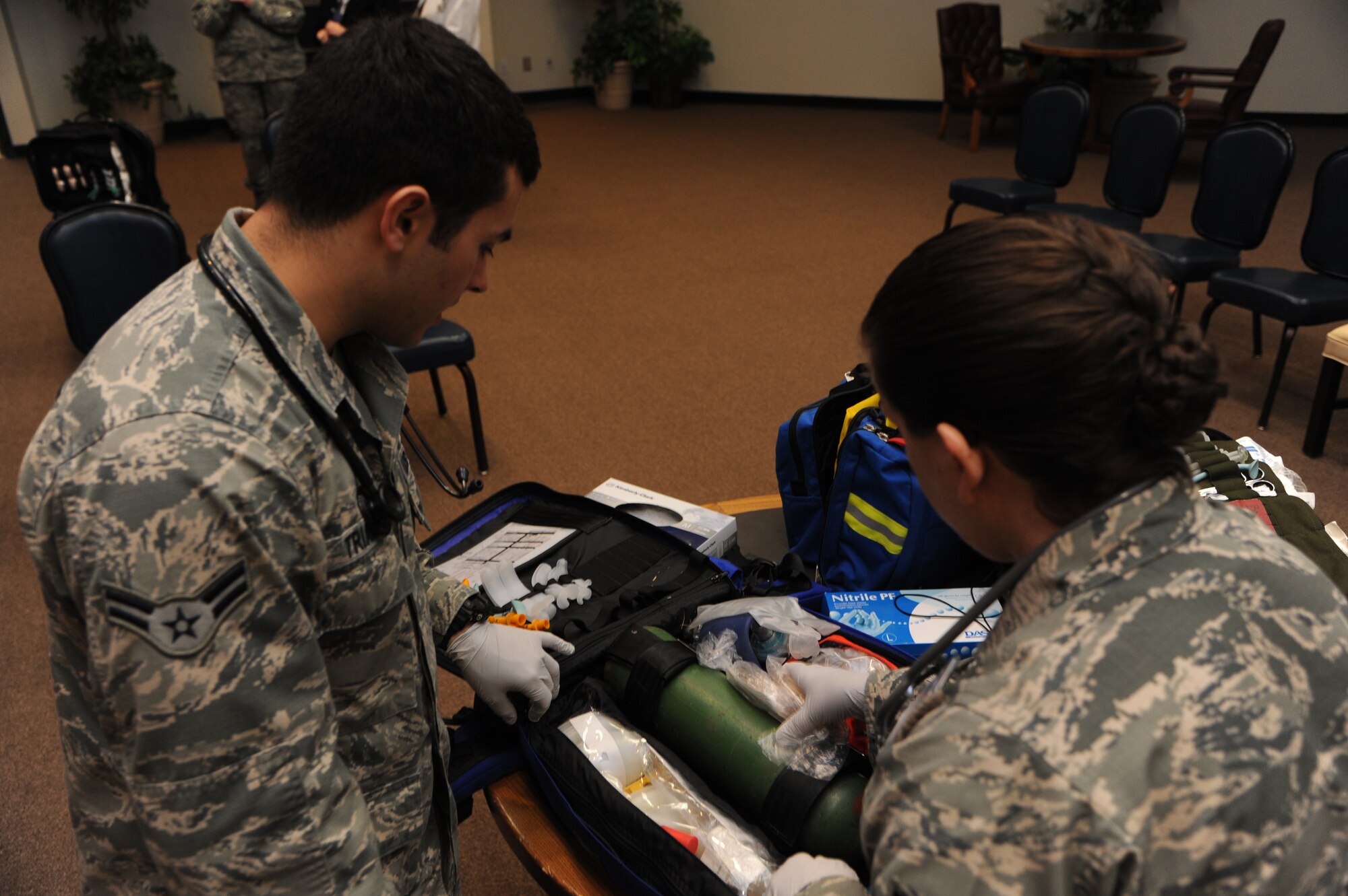 ALTUS AIR FORCE BASE, Okla. – U.S. Air Force Airman 1st Class Michael Triana, 97th Medical Operations Squadron pediatrics technician, and U.S. Air Force Tech. Sgt. Tina Belesky, 97th MDOS NCO in charge of Family Health, inspect an oxygen tank during a severe weather exercise inside the Freedom Community Center March 12, 2014. Field response bags include items that could be beneficial in helping treat patients in the event of an emergency. (U.S. Air Force photo by Airman 1st Class J. Zuriel Lee/Released)