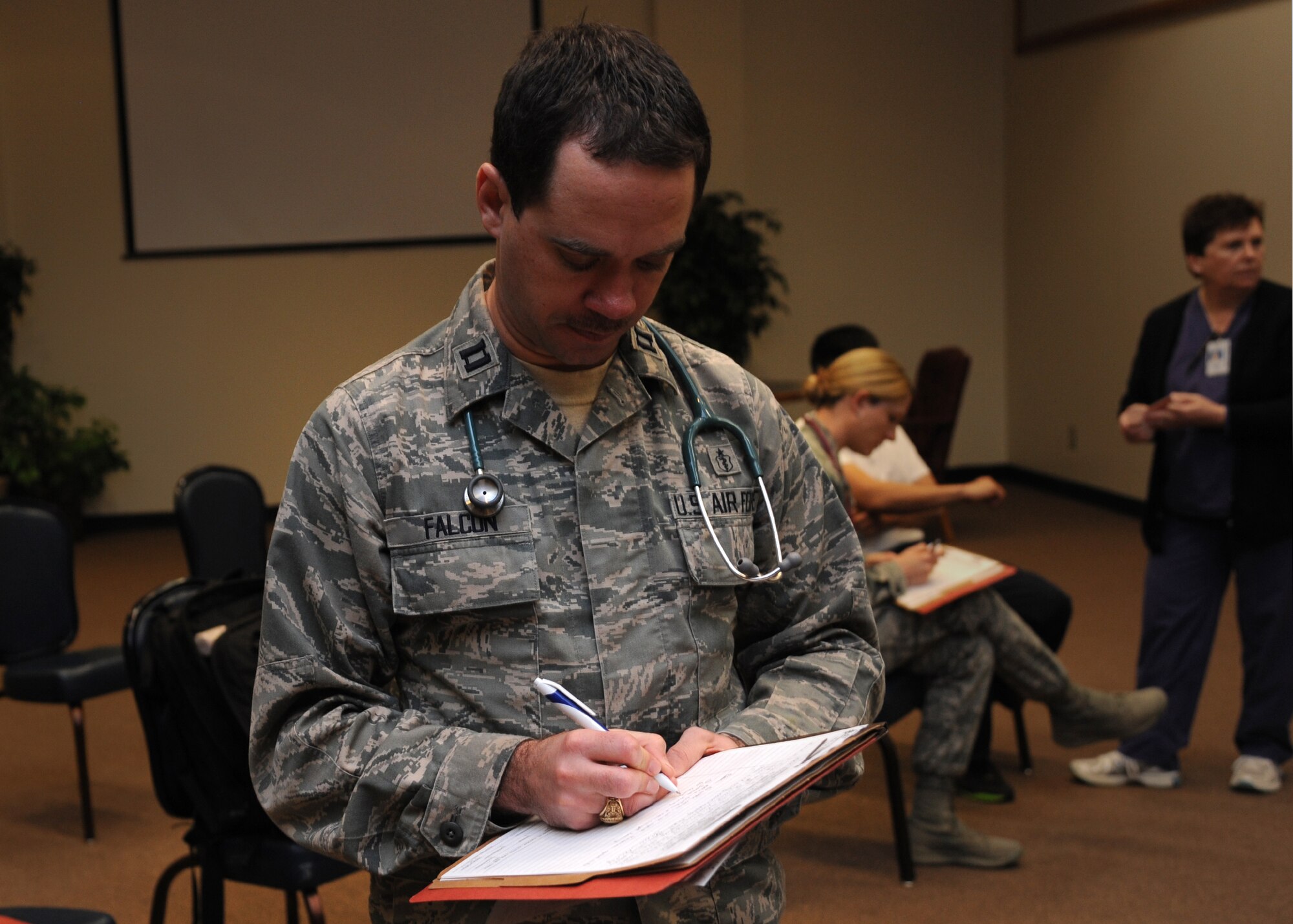 ALTUS AIR FORCE BASE, Okla. – U.S. Air Force Capt. Corey Falcon, 97th Medical Operations Squadron pediatrics element chief, takes notes during a severe weather exercise in the Freedom Community Center March 12, 2014. Falcon ensured patients received proper medical attention. (U.S. Air Force photo by Airman 1st Class J. Zuriel Lee/Released)