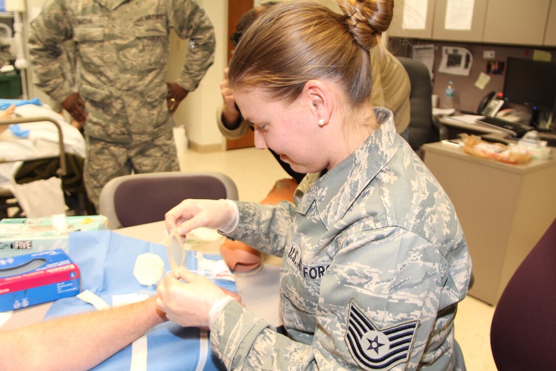 The 932nd Airlift Wing Noncommissioned Officer in Charge of Basic Life Support for the Medical Squadron, Tech Sgt. Monica Hanson prepares to insert an IV-line in another Reserve member.  The members of MDS underwent Emergency Medical Technician training during the March unit training assembly. (U.S. Air Force Photo/ Staff Sgt. Meiko Schill)