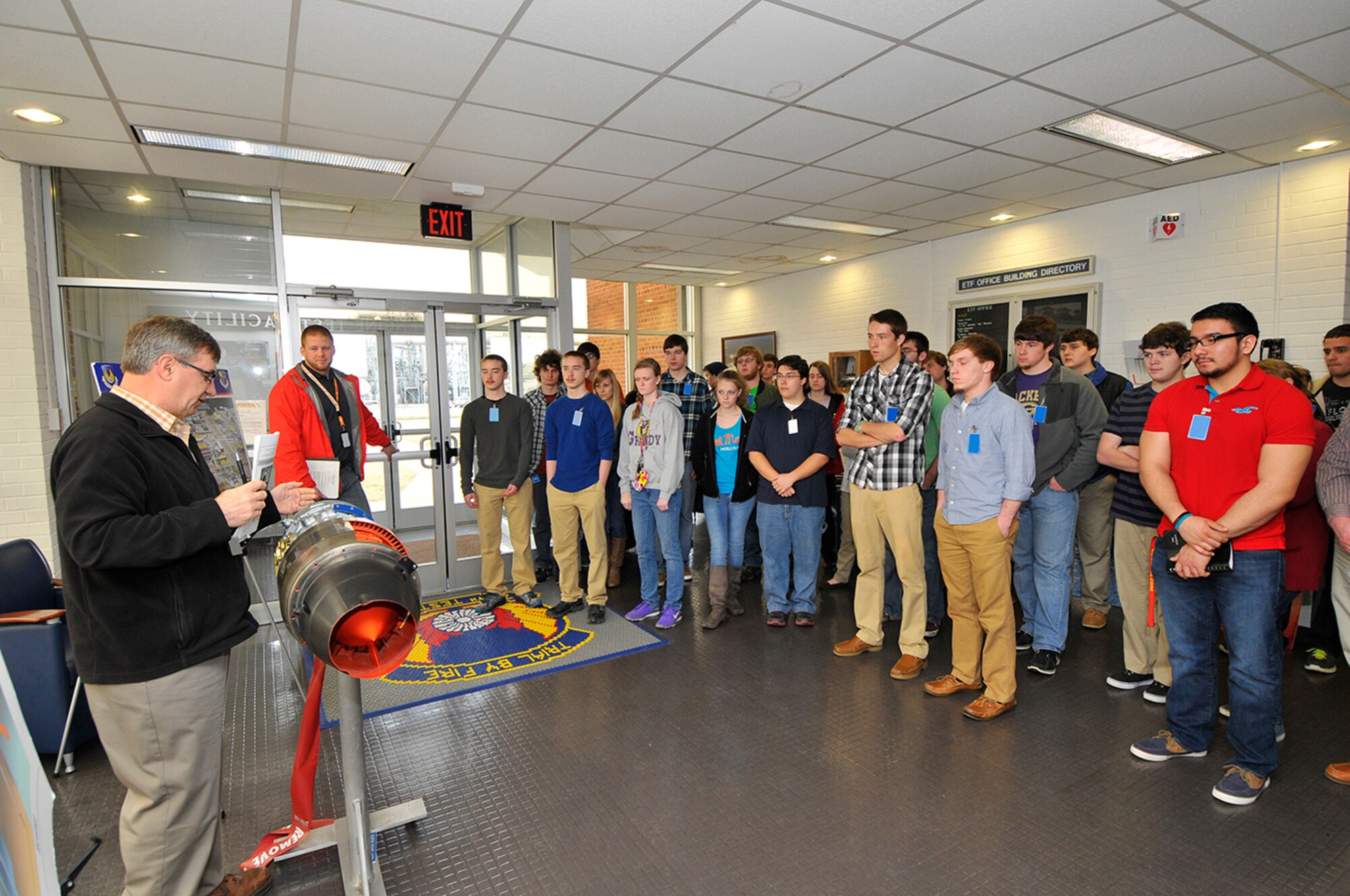 Gene Klingensmith (far left), an engineer in the AEDC Aeropropulsion Ground Test Branch, describes the mechanics of an engine to aspiring, young engineers attending a tour of AEDC during Engineer for a Day. (Photo by Jacqueline Cowan)