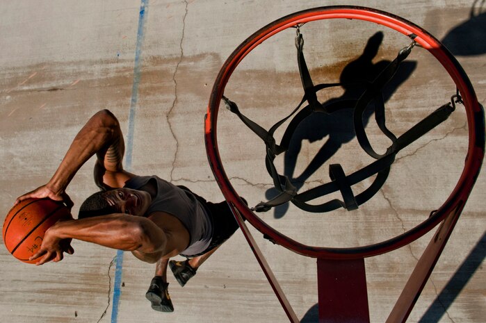 U.S. Air Force Senior Airman Nathaniel Mills, 99th Security Forces Squadron patrolman, dunks a basketball Sept. 18, 2013, at a basketball court in Las Vegas. Mills, whose passion for basketball started in 1995 while watching the Chicago Bulls play, was training to try out for the Air Force basketball team last October. (U.S. Air Force photo/Senior Airman Daniel Hughes)