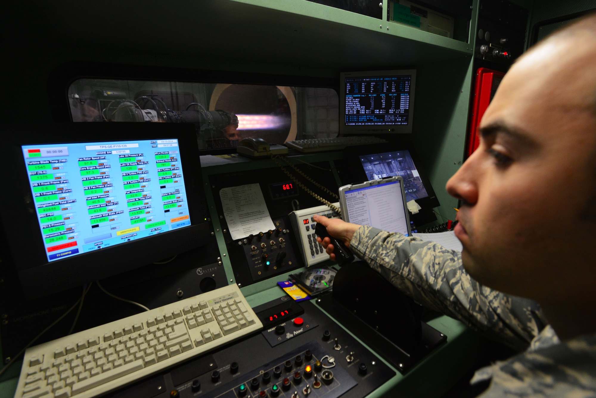 U.S. Air Force Staff Sgt. Samuel Allen, 20th Component Maintenance Squadron jet engine craftsman, watches a monitor while pushing a throttle inside a control booth at the engine test facility, Shaw Air Force Base, S.C., March 13, 2014. Allen determined how far to push the throttle without surpassing the engine’s maximum fan rotation which is 8,200 rotations per minute. (U.S. Air Force photo by Airman 1st Class Jensen Stidham/Released)