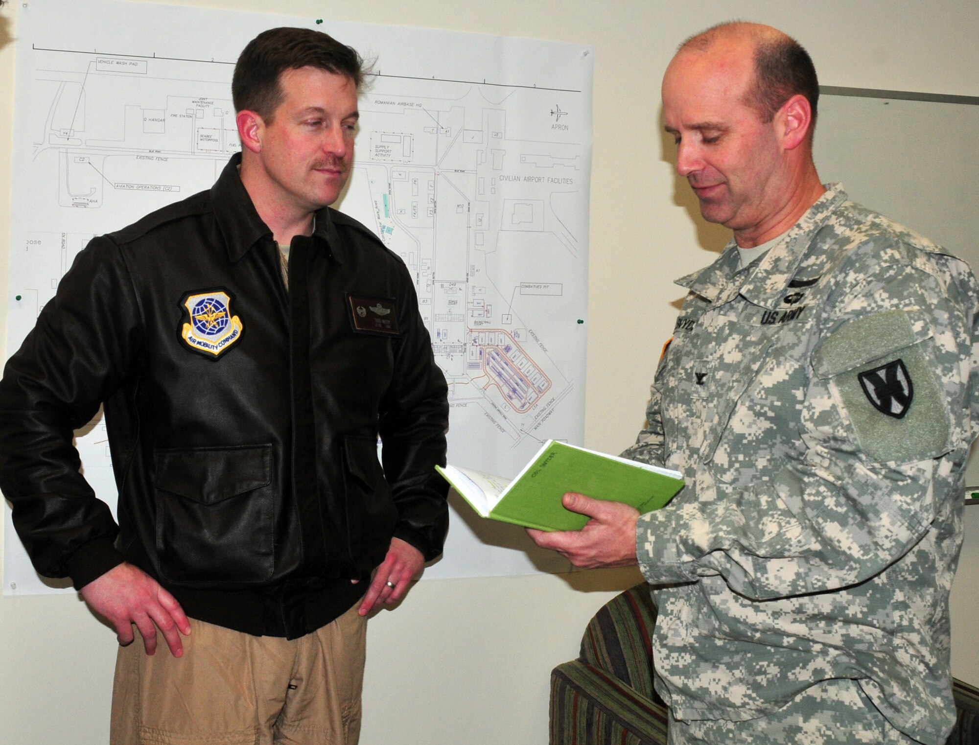 Air Force Lt. Col. Todd McCoy confers with Army Col. Michael C. Snyder, the deputy commanding officer of the 21st Theater Sustainment Command and officer in charge of the Regional Support Element, March 11, at Mihail Kogalniceanu Air Base, Romania, following the colonel’s daily key leader synchronization meeting. (U.S. Army courtesy photo)