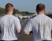 Team Mildenhall members pace each other during the wing 5 km run March 14, 2014, on RAF Mildenhall, England. The monthly run is mandatory for 100th ARW Airmen and open to all Team Mildenhall members. Participants run a designated route along the perimeter of the base, starting and ending at the Hardstand Fitness Center. (U.S. Air Force photo by Airman 1st Class Preston Webb/Released)