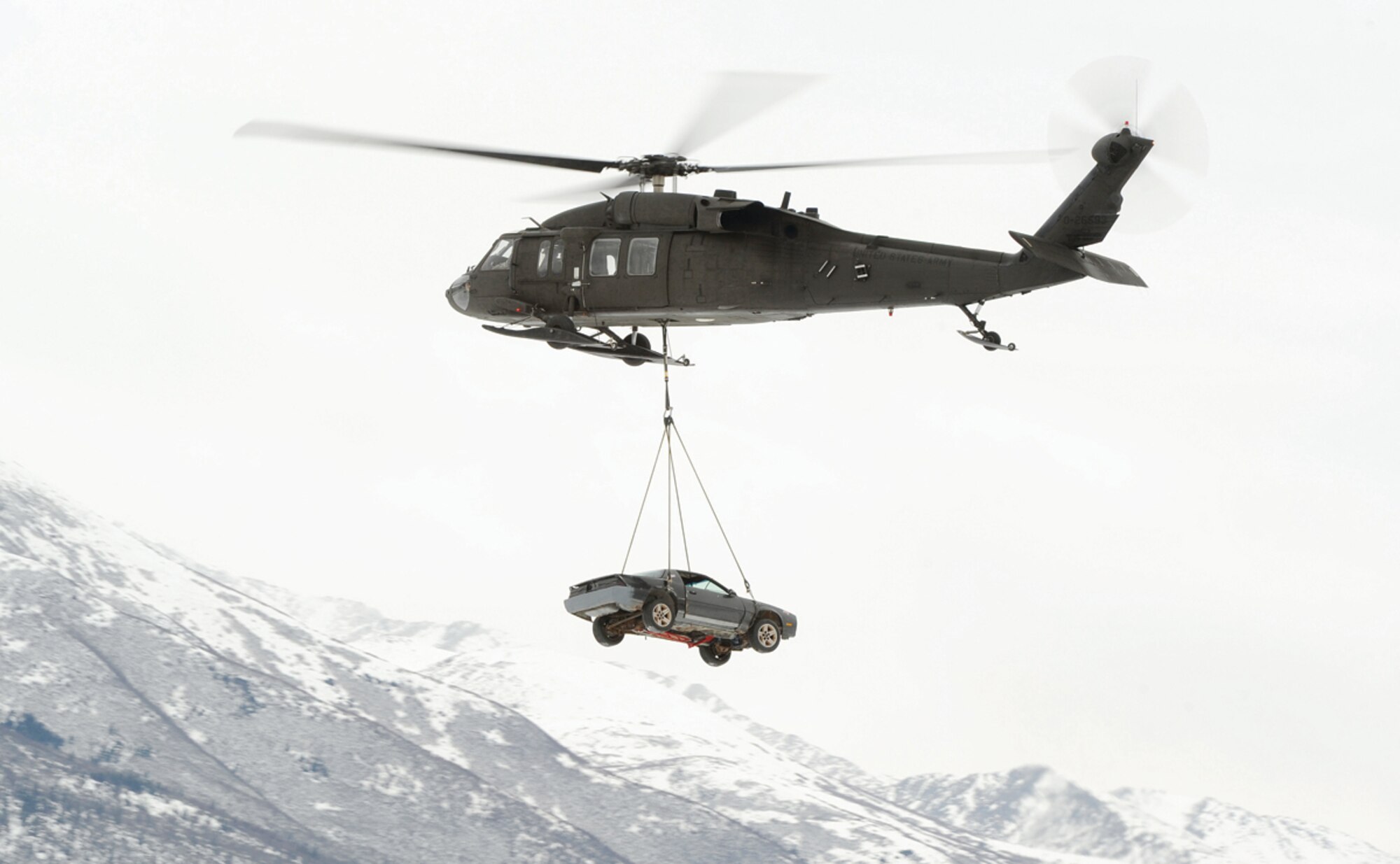 An Alaska Army National Guard UH-60 transports a vehicle from Bryant Army Airfield to Arctic Valley after Soldiers assigned to the 1-501st Infantry prepared it for a sling load operation on JBER March 4. (U.S. Air Force photo/Justin Connaher)