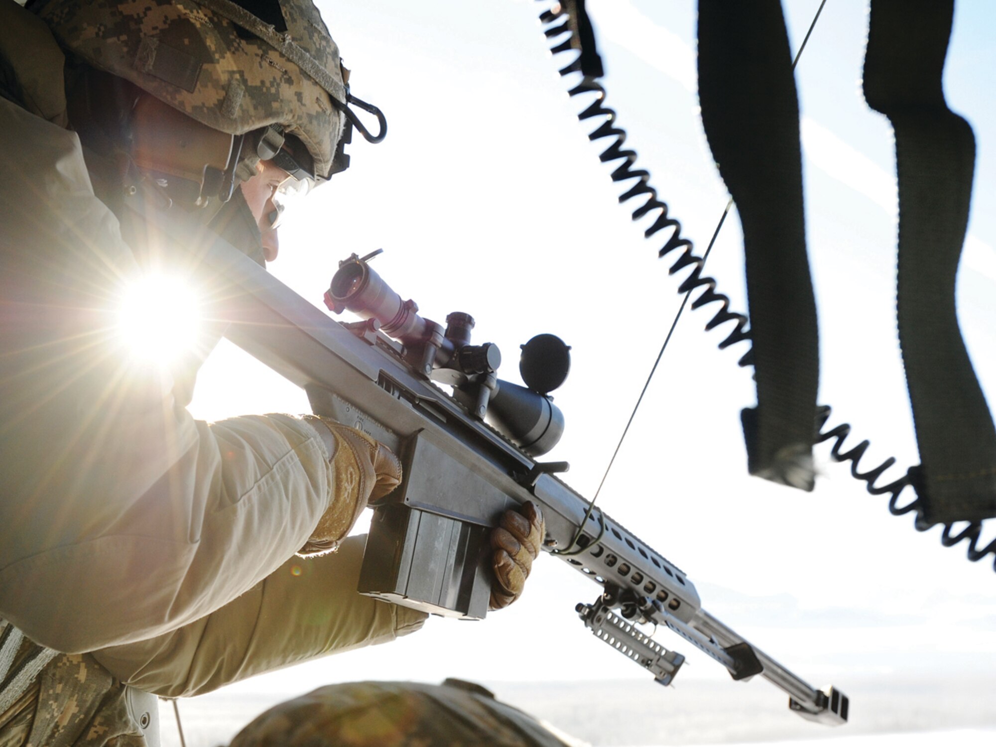 Spc. Jonathan Savage, a native of Mesquite, Texas, assigned to the 1st Battalion (Airborne), 501st Infantry Regiment, lines up a shot with an M107 .50-caliber Long Range Sniper Rifle from an aerial platform in a UH-60 Black Hawk helicopter over Malemute drop zone on Joint Base Elmendorf-Richardson March 7. (U.S. Air Force photo/Justin Connaher)