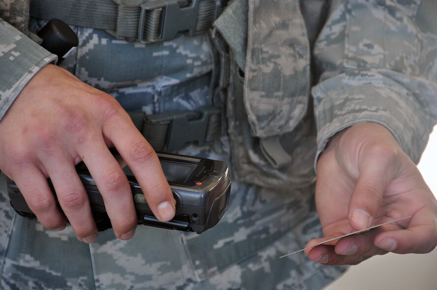 Airman Zachary Buonacorsi, 60th Security Forces Squadron, uses a scanner to verify a government identification card through the Defense Biometric Defense System March 6 at the main gate on Travis. (U.S. Air Force photo/Senior Airman Madelyn Brown)