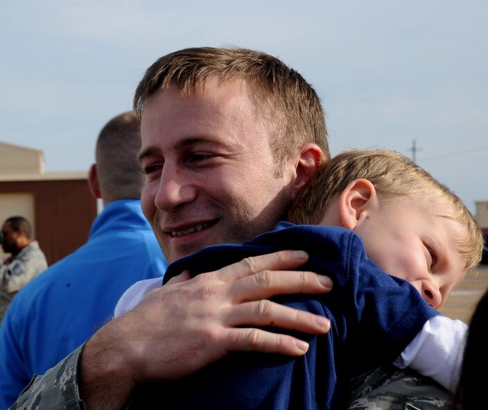 An Airman hugs his son on Barksdale Air Force Base, March 7, 2014. Airmen assigned to the 2nd Bomb Wing, were returning from a six month deployment to Andersen Air Force Base, Guam, in support of the Continuous Bomber Presence. (U.S. Air Force photo/Staff Sgt. Sean Martin)