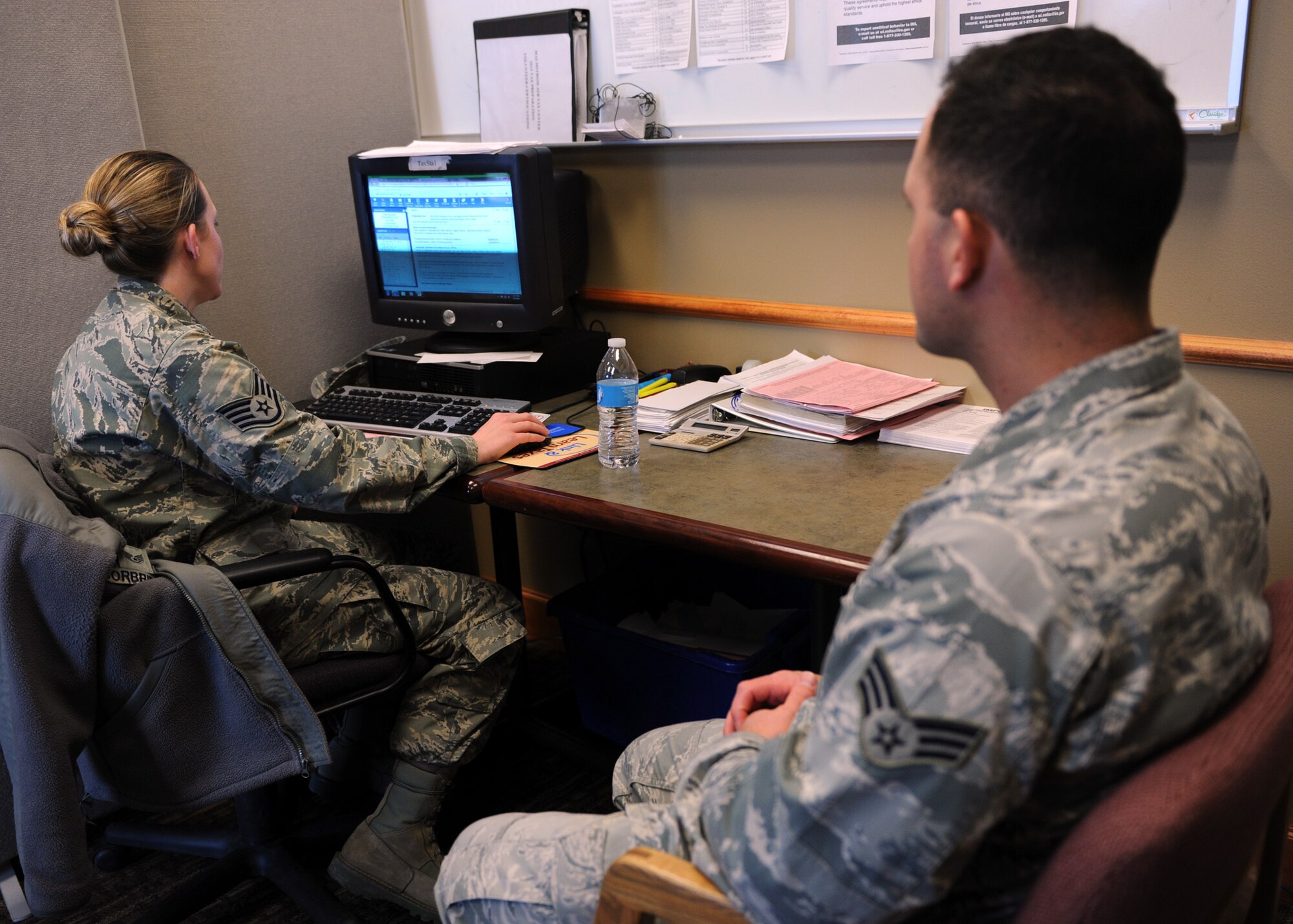 Staff Sgt. Kimberly Corbridge, 341st Missile Wing legal office paralegal (left), asks Senior Airman Peter Navarini, 819th RED HORSE Squadron pavement and construction operator (right), questions from his W-2 at the Malmstrom Air Force Base Tax Center.  Airmen, retirees and dependents can get a free tax return at the tax center, located at the Grizzly Bend in Room 12 through April 15. (U.S. Air Force photo/Senior Airman Katrina Heikkinen)