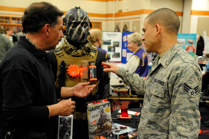 Larry LaRoque, Electric City Airsoft co-owner (left), speaks with Senior Airman Cecilio Fantauzzi-Mendoza, 819th RED HORSE Squadron pavements and equipment apprentice, about what his business offers military members and the gear during Malmstrom’s 2014 Community Fair on March 7 at the Grizzly Bend. According to local business owners, the fair has opened many doors and created opportunities that would not have been possible without an event like this. (U.S. Air Force photo/Airman 1st Class Collin Schmidt)  