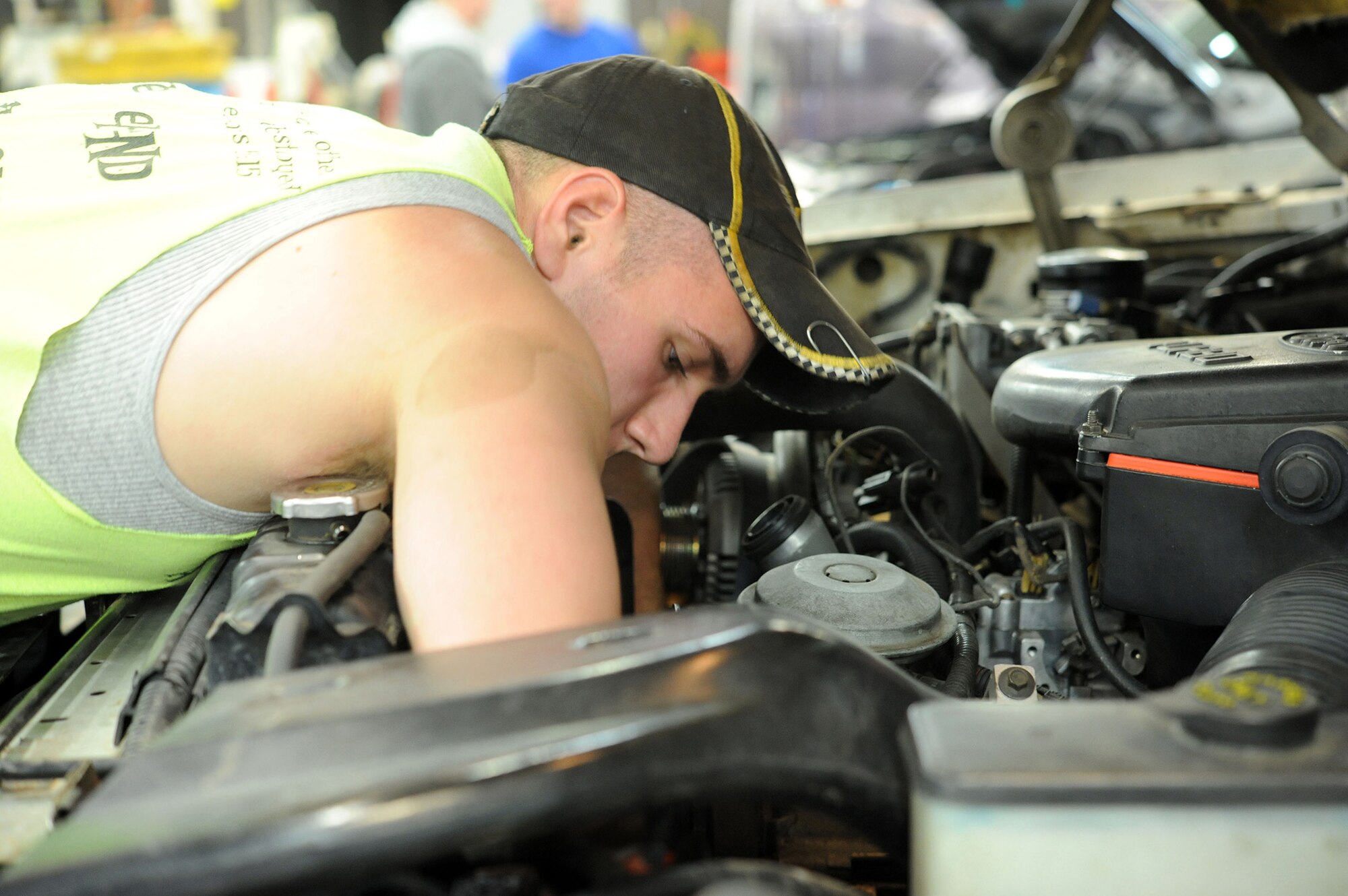 Airman 1st Class Jeremy McNeal, 341st Logistics Readiness Squadron vehicle maintenance apprentice, reaches into his engine compartment to turn a socket wrench. McNeal was replacing the serpentine belt on his truck at the base auto hobby shop March 8. (U.S. Air Force photo/Airman 1st Class Joshua Smoot)