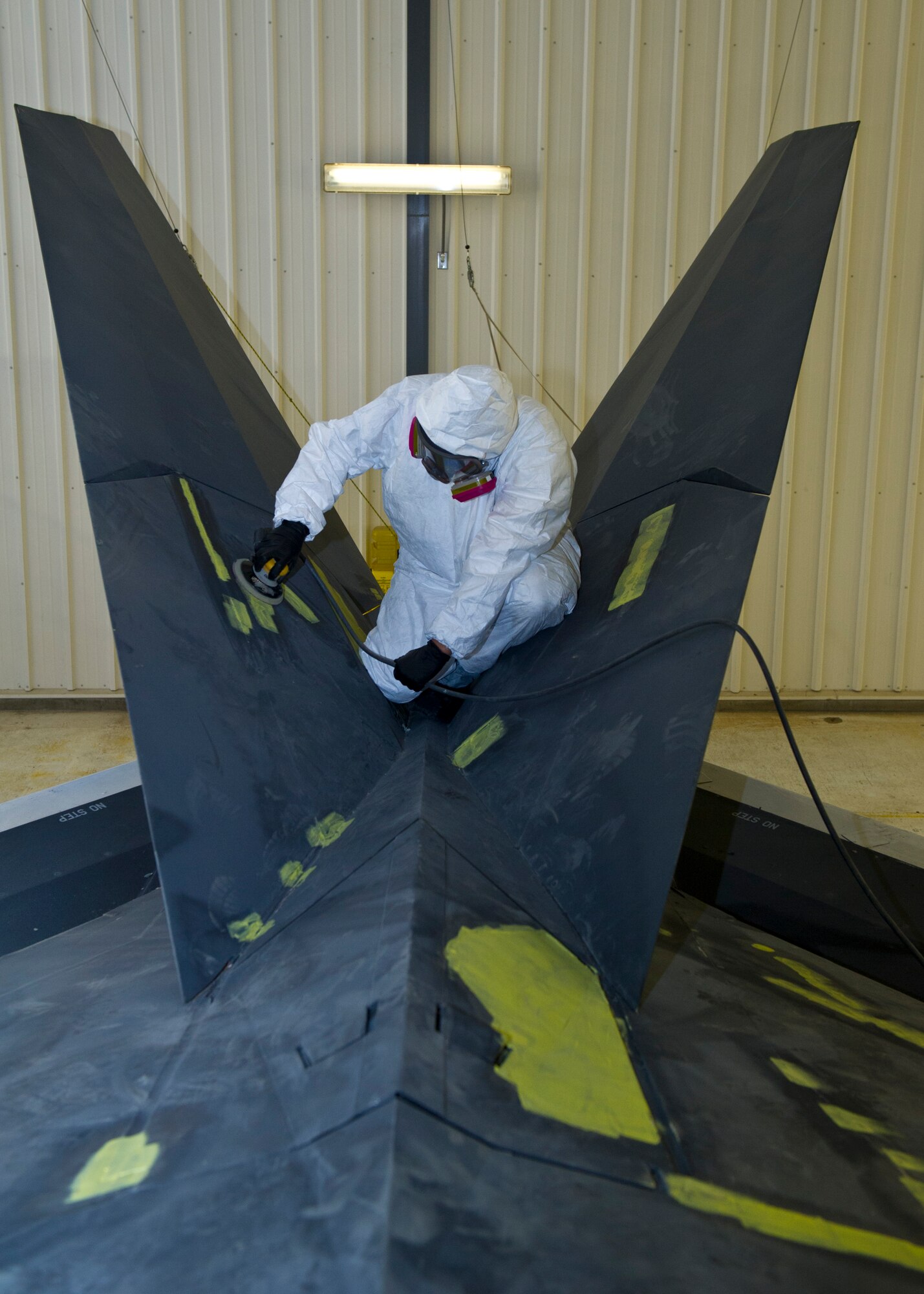 Senior Airman Trevor Mendez from the 49th Maintenance Squadron, fabrication flight sands the tail of the F-117 at Holloman Air Force Base, N.M., March 13. The F-117 has been on static display in Holloman’s Heritage Park since its retirement in 2008. Due to sun and inclement weather damage, the 49 MXS removed and towed the aircraft to the hangar to begin the restoration process. Airmen will perform structural maintenance on the Nighthawk and give the aircraft a fresh paint job before returning it for display in Heritage Park. (U.S. Air Force photo by Airman 1st Class Leah Ferrante/Released)