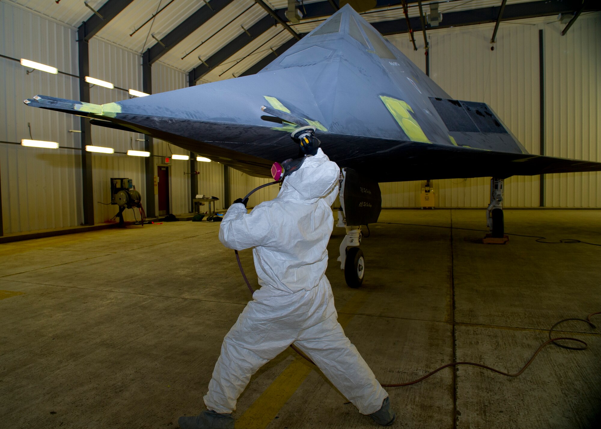 Staff Sgt. Julian Arroyo from the 49th Maintenance Squadron, fabrication flight, sands the F-117 at Holloman Air Force Base, N.M., March 13. The F-117 has been on static display in Holloman’s Heritage Park since its retirement in 2008. Due to sun and inclement weather damage, the 49 MXS removed and towed the aircraft to the hangar to begin the restoration process. Airmen will perform structural maintenance on the Nighthawk and give the aircraft a fresh paint job before returning it for display in Heritage Park. (U.S. Air Force photo by Airman 1st Class Leah Ferrante/Released)