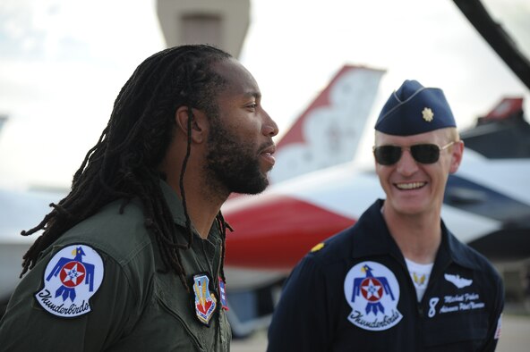 Larry Fitzgerald, Arizona Cardinals wide reciever, talks to Maj. Michael Fisher, U.S. Air Force Thunderbirds advance pilot/narrator, before taking a flight in a Thunderbird jet March 14. Fisher served as an F-16 instructor pilot and flight commander for the 310th Fighter Squadron at Luke Air Force Base. (U.S. Air Force photo by Airman 1st Class Pedro Mota)