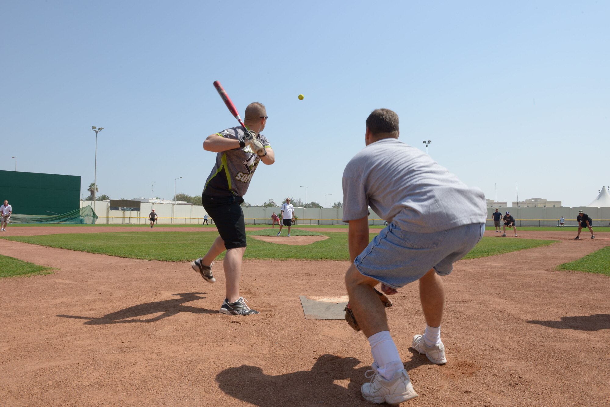 Airmen and Soldiers participate in a softball game during Military Appreciation Day hosted by the American School of Doha in Qatar, Mar. 7, 2014. Through the 379th Air Expeditionary Wing’s private organization Jar Saleh, Arabic for ‘Good Neighbor,’ both the 379th AEW at Al Udeid Air Base, Qatar, and the Area Support Group at Camp As Sayliyah, Qatar, have been heavily involved at ASD through a variety of volunteer opportunities. The American School of Doha showed their appreciation by hosting the 4th annual Military Appreciation Day for the Airmen, Soldiers, Sailors and Marines deployed to AUAB and CAS. (U.S. Air Force photo/Senior Airman Hannah Landeros)