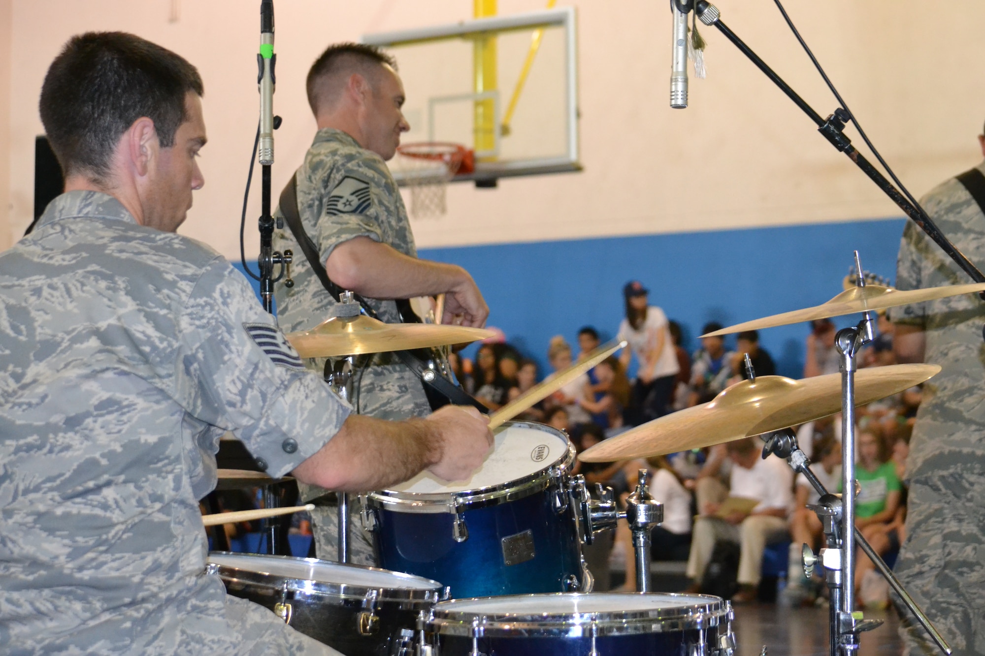 “Hypersonic,” the band assigned to U.S. Air Forces Central Command, performs for 150 8th graders from the American School of Doha at Al Udeid Air Base, Qatar, Mar. 10, 2014.  The 379th Air Expeditionary Wing hosted a field trip for ASD students, from 73 countries and showcased the variety of capabilities in the U.S. Air Force.  The AFCENT band concluded the day performing a variety of hit songs that got the Airmen and children singing and dancing.  Master Sgt. Jeremy Laukhuf, on bass guitar, and Technical Sgt. Steven Helfand, on drum set, are both deployed from Yokota Air Base, Japan.  Laukhuf, is native of Lima, Oh. and Helfand is a native of Silver Spring, Md.  (U.S. Air Force Photo by Maj. Nicole David)