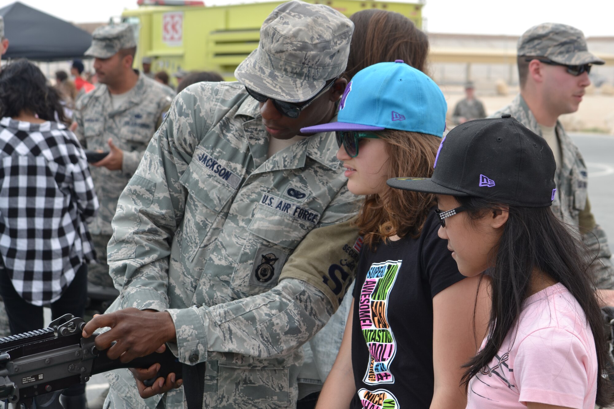 Senior Airman Justin Jackson, a Mobile, Ala. native and Security Forces Defender deployed from Keesler Air Force Base, Miss., demonstrates the operation and setting of the sights on the M249 Light Machine Gun to 8th graders from the American School of Doha at Al Udeid Air Base, Qatar, Mar. 10, 2014.  The 379th Air Expeditionary Wing hosted a field trip for ASD students, from 73 countries and showcased the variety of capabilities in the U.S. Air Force, affording them the opportunity see where the Airmen live and work and experience hands-on interaction for various careers.  (U.S. Air Force Photo by Maj. Nicole David)