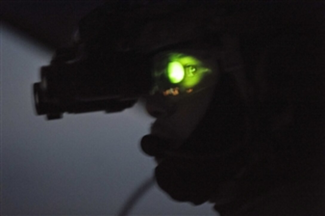 As seen through a night-vision device, U.S. Air Force Staff Sgt. Josh Martin scans for threats during a goggle training mission with Afghan airmen in Kabul, Afghanistan, March 13, 2014. Martin, an Mi-17 advisor, is assigned to the 438th Air Expeditionary Wing, NATO Air Training Command Afghanistan.