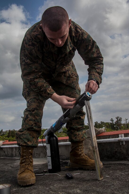 Lance Cpl. Gage E. Mock, a field radio operator with the 31st Marine Expeditionary Unit and a native of Gridley, Ill., lays the last strip of duct tape on a field-expedient ultra-high frequency antenna atop a building, March 14. Four soda cans wrapped in copper strands inside an RF cable wire and mounted on a steady base held enough signal strength to send and receive radio messages in the event the primary and secondary UHF systems became inoperable, adding an extra communication asset. The training is part of the 31st MEU’s Certification Exercise, where the MEU’s operational capabilities are evaluated by the Special Operations Training Group, III Marine Expeditionary Force, during the unit’s regularly-scheduled Spring Patrol.