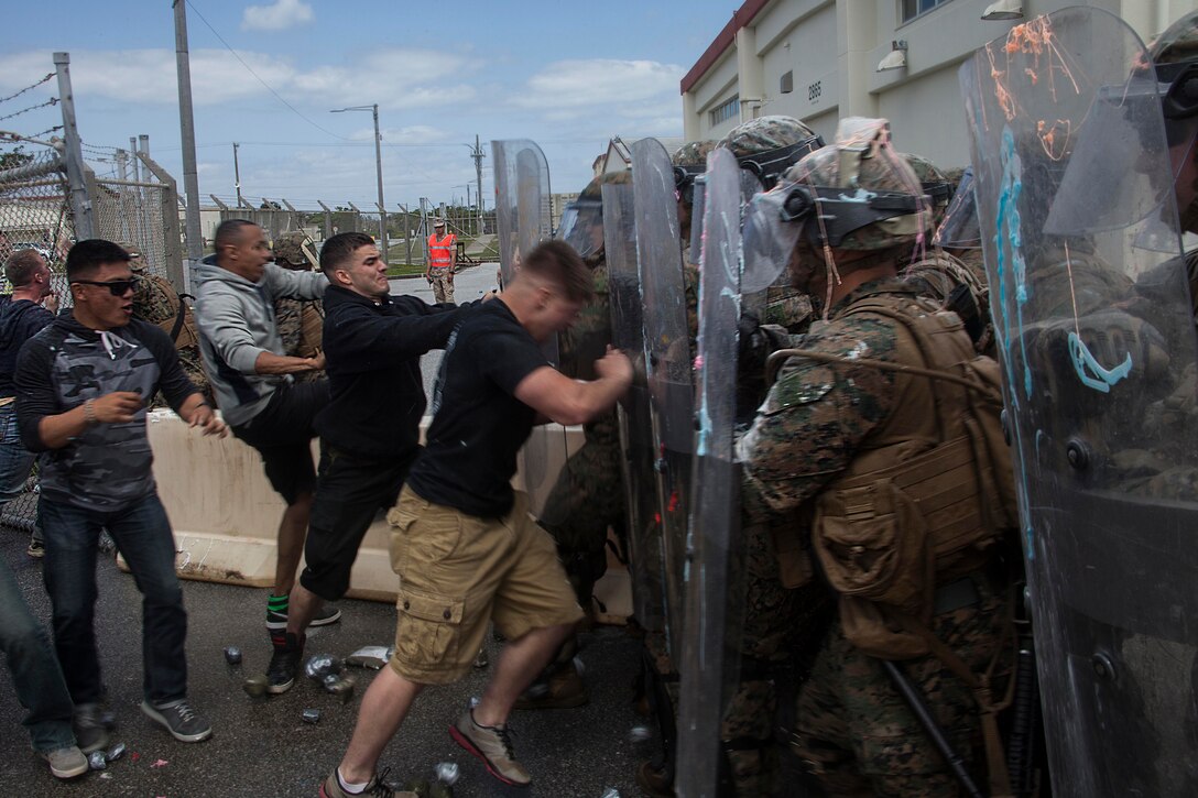 Role-players rush through the gate at Marines with Battery G., Battalion Landing Team 2nd Battalion, 5th Marines, 31st Marine Expeditionary Unit, the security force for an American embassy during a mock hostile protest, March 15. The simulated embassy is home to the 31st MEU’s Forward Command Element, a command cell that coordinates with a host nation’s government to organize the delivery of humanitarian assistance and disaster relief supplies to people in need. The HA/DR training is in support of the 31st MEU’s Certification Exercise, a training package that tests the capabilities of the MEU in a variety of scenarios and is evaluated by members of the Special Operations Training Group, III Marine Expeditionary Force.