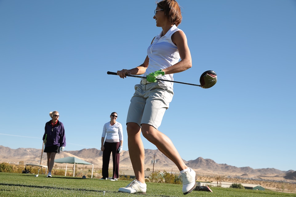 Elizabeth Webb, Marine spouse, celebrates after a well-placed practice swing before the opening game of the Ladies Golf League at the Desert Winds Golf Course, March 10, 2014. The league offers a place for women to train and learn the skills of golf.