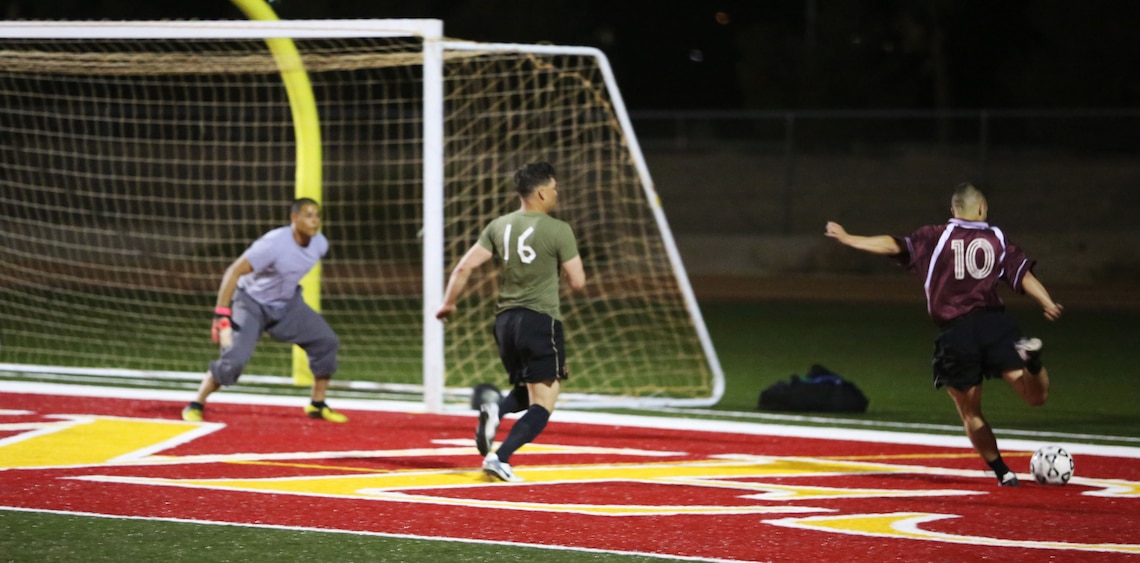 Cpl. Alejandro Bedoya, mid-fielder, Headquarters Battalion Team 2, strikes the ball during the opening night of the 2014 Intramural Outdoor Soccer League at the newly renovated Felix Field, March 10, 2014. Starting next week, games will consist of two, 30 to 35-minute halves, allowing the players to have more opportunity to get insync with one another and build consistency with their teammates. 