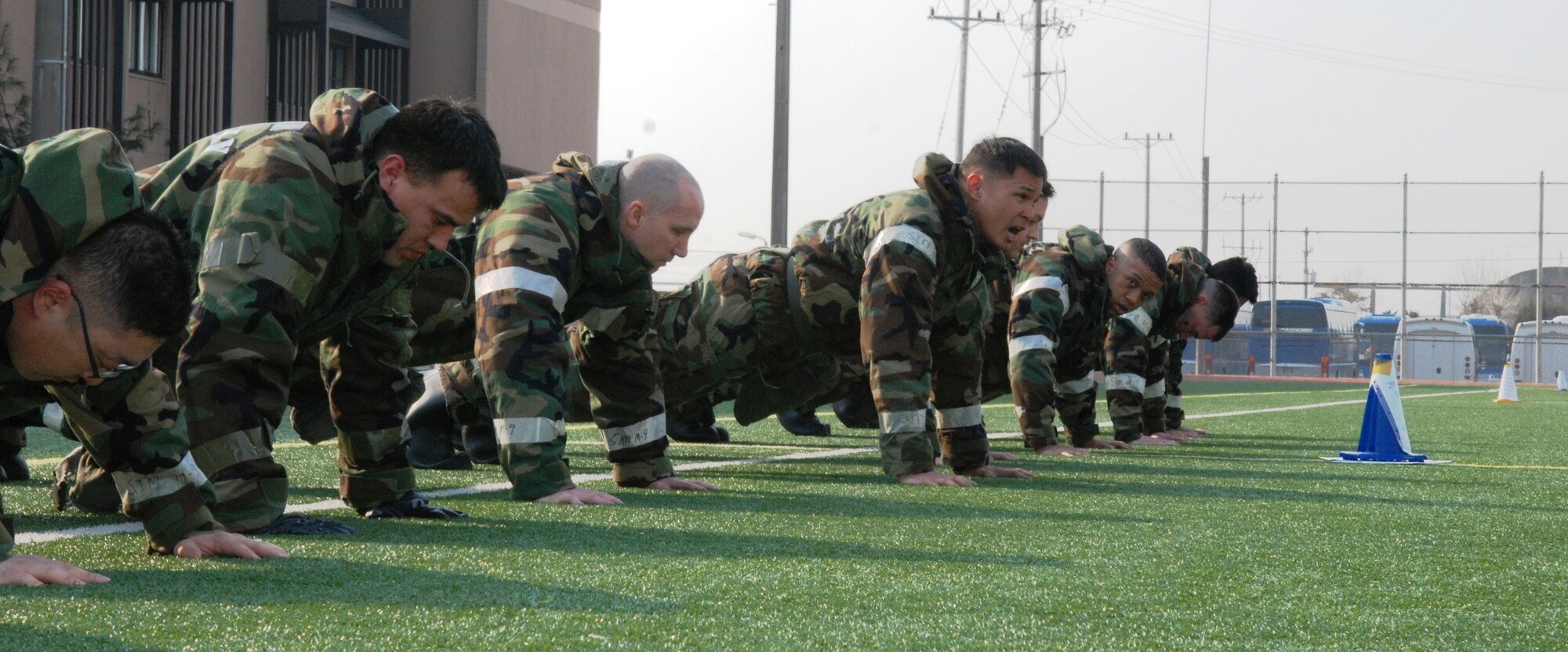 OSAN AIR BASE, Republic of Korea - Seventh Air Force volunteers lead the formation during the Medal of Honor Push-Ups at the end of staff PT March 14, 2014. Monthly staff PT sessions end with the tradition of performing a push-up for each of the 10 7th AF members who have received the Medal of Honor. The event is led by a group of volunteers who call out the MOH recipient's name and lead the formation in the exercise.  (U.S. Air Force photo by Tech. Sgt. Thomas J. Doscher)