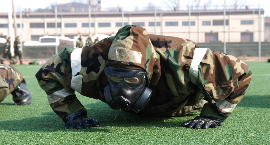 OSAN AIR BASE, Republic of Korea - A 7th Air Force staff member performs push-ups in MOPP 4 during staff PT March 14, 2014. The 7th AF staff conducts a staff-wide PT session every month, but this is the first time the command has done PT in MOPP gear. Members had to perform a circuit that consisted of push-ups, crunches, low-crawls, rush 'n rolls and buddy carries, ending with a sprint to the finish.  (U.S. Air Force photo by Tech. Sgt. Thomas J. Doscher)