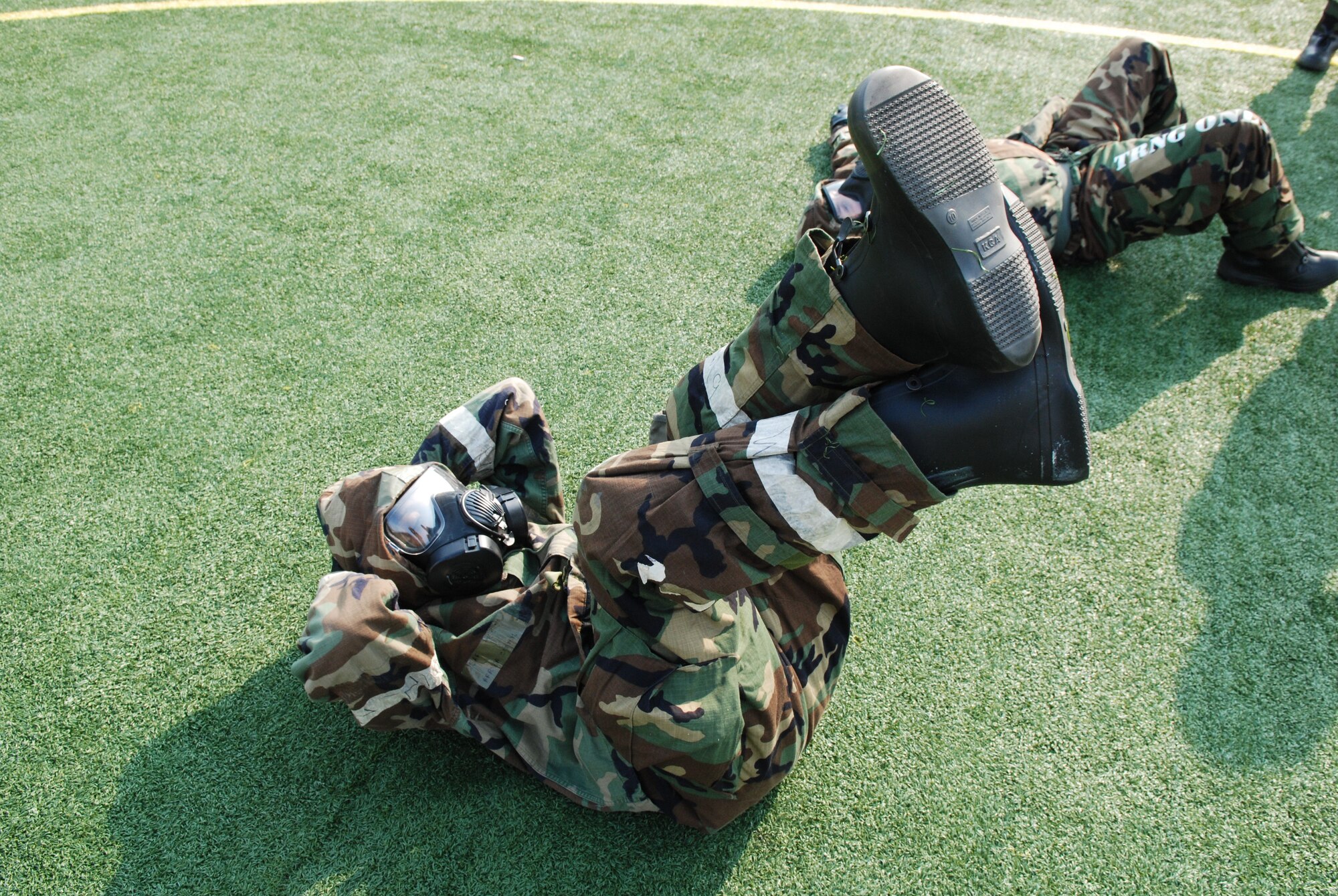 OSAN AIR BASE, Republic of Korea - A 7th Air Force staff member performs crunches in MOPP 4 during staff PT March 14, 2014. The 7th AF staff conducts a staff-wide PT session every month, but this is the first time the command has done PT in MOPP gear. Members had to perform a circuit that consisted of push-ups, crunches, low-crawls, rush 'n rolls and buddy carries, ending with a sprint to the finish.  (U.S. Air Force photo by Tech. Sgt. Thomas J. Doscher)