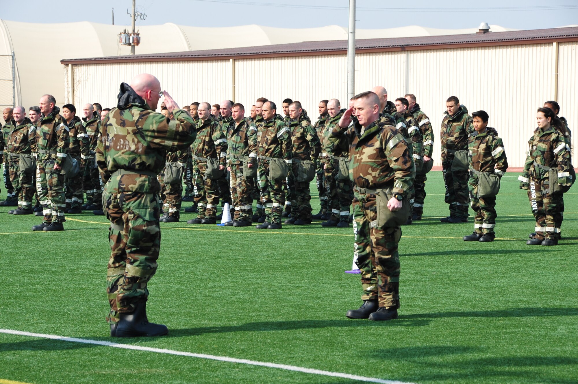 OSAN AIR BASE, Republic of Korea - Chief Master Sgt. Derrick Moniz, 7th Air Force A7, reports the formation ready to Col. Christopher Cotts, 7th AF Chief of Staff at the beginning of staff PT on Osan Air Base, Republic of Korea, March 14, 2014. Staff-wide PT is a monthly requirement for 7th AF, but this was the first time the unit conducted PT in MOPP gear. Staff members were required to low crawl, rush 'n roll, perform buddy carries, do push-ups, crunches and side-straddle hops. (U.S. Air Force photo by Maj. Richelle Dowdell)