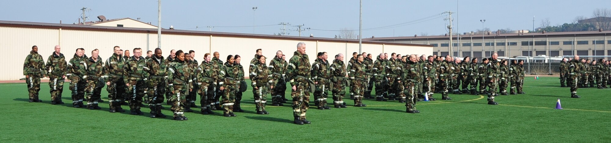 OSAN AIR BASE, Republic of Korea - Members of the 7th Air Force staff form up at MOPP 2 for unit PT on Osan Air Base, Republic of Korea, March 14, 2014. The 7th AF staff mixed things up a little at this month's staff PT by working out in their MOPP gear. Staff members were required to low crawl, rush 'n roll, perform buddy carries, do push-ups, crunches and side-straddle hops. (U.S. Air Force photo by Maj. Richelle Dowdell)