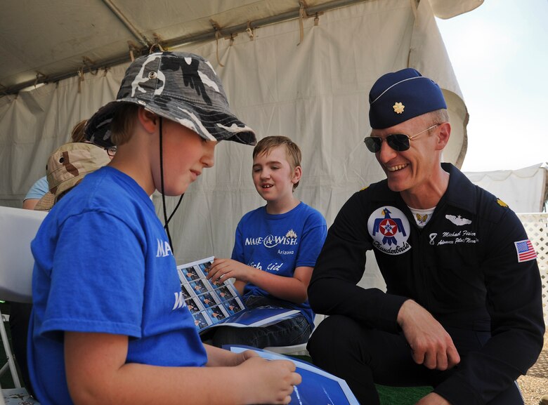 Maj. Michael Fisher, U.S. Air Force Demonstration Squadron advance pilot and narrator, meets with Samuel Schow after the Thunderbirds practice performance Mar. 14 at Luke Air Force Base. Samuel and his brother Aidan both suffer from a disorder called nemaline myopathy, requiring both to utilize feeding tubes. (U.S. Air Force Photo by Staff Sgt. Darlene Seltmann)