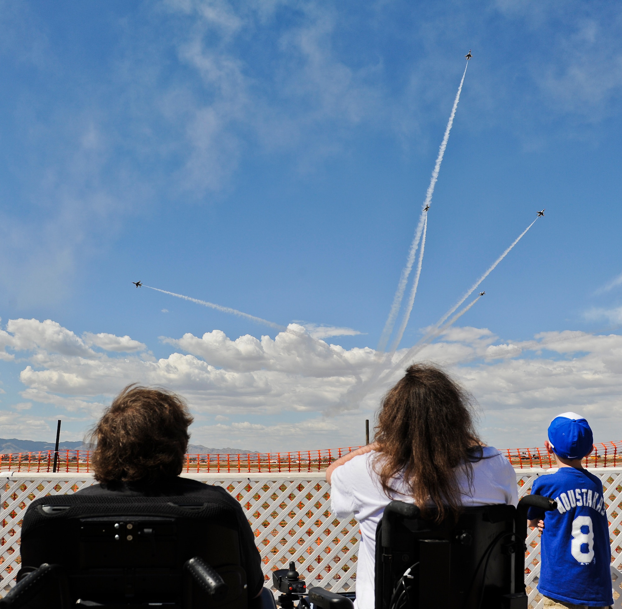 Kevin (left) and Tom Groeger watch the U.S. Air Force Air Demonstration Squadron Thunderbirds perform the delta burst during their practice performance Mar. 14 at Luke Air Force Base. The Groeger brothers both suffer from muscular dystrophy, which has progressively gotten worse. Both boys have lost the ability to walk due to the disorder weakening their muscles. (U.S. Air Force Photo by Staff Sgt. Darlene Seltmann)