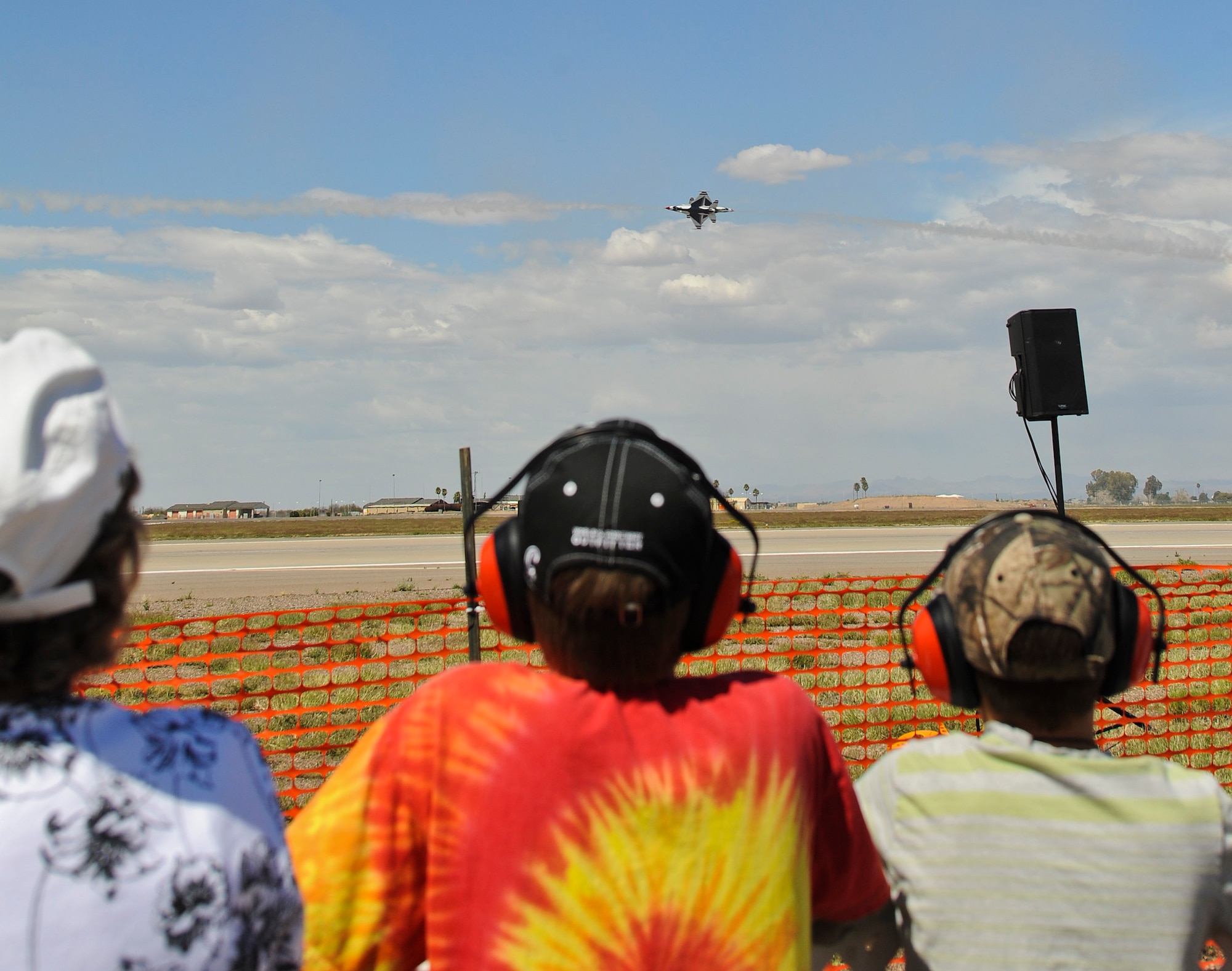 Children from the special needs event watch the U.S. Air Force Air Demonstration Squadron Thunderbirds perform the Inverted Opposing Knife Edge maneuver during their practice performance Mar. 14 at Luke Air Force Base. OveMore than 100 special needs children and families showed up for the event. (U.S. Air Force Photo by Staff Sgt. Darlene Seltmann)
