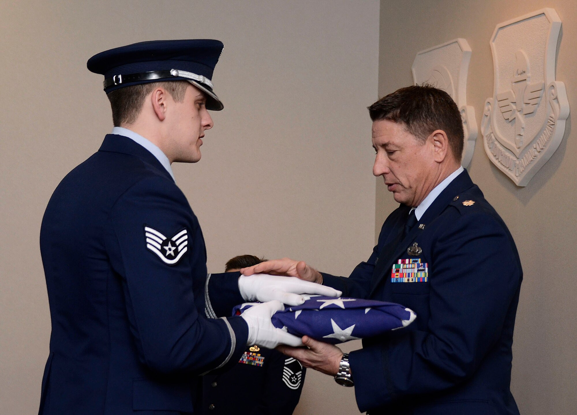 Lt. Col. Richard Barker, 94th Airlift Wing inspector general, receives the U.S. Flag from Staff Sgt. Joshua Koon of the 94th AW Honor guard during his retirement ceremony honoring 38 years of military service Feb. 1. (U.S. Air Force photo/Don Peek)