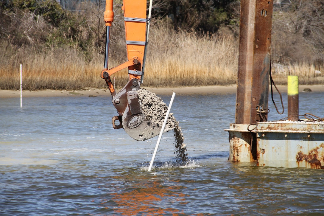 A crane moves fossilized oyster shell from a barge into waters in the Lafayette River.  This Norfolk International  Terminal  six-acre sanctuary reef is one of five reefs.  The reef’s being constructed as part of the Craney Island Eastward Expansion project. The oyster mitigation process of the project will be completed in June 2014. All of the reefs will be permanent oyster sanctuaries.