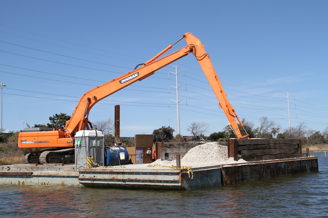 Approximately 14,000 oyster shell is being placed on sanctuary reefs spanning six acres near the Norfolk International  Terminal  in the Lafayette River. Mounds of oyster shell are staged on barges to be placed on oyster reefs marked by white poles in the water. A crane then moves the fossilized oyster shell onto the reef. This Norfolk International  Terminal  six-acre sanctuary reef is one of five reefs.  The reef’s being constructed as part of the Craney Island Eastward Expansion project. The oyster mitigation process of the project will be completed in June 2014. All of the reefs will be permanent oyster sanctuaries. 
