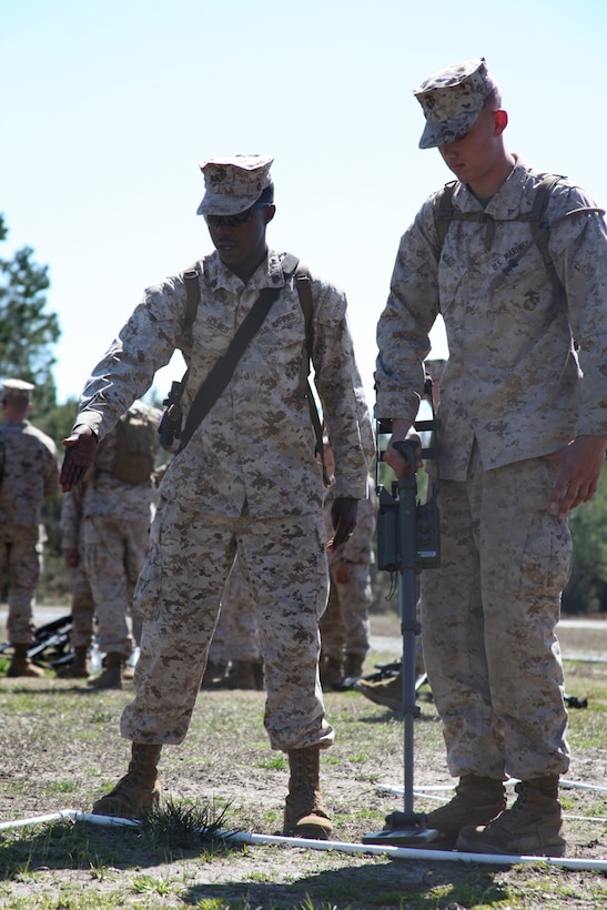 Sgt. Trumaine Holmes (left) instructs Lance Cpl. Creston Wood (right) on proper use of a compact metal detector at Marine Corps Base Camp Lejeune, March 11. During the training, the Marines with Marine Wing Support Squadron 271 learned the basics of counter-improvised explosive device operations. Holmes and Wood are combat engineers with MWSS-271.  